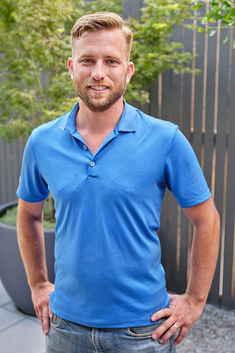 man in a blue shirt standing outside
