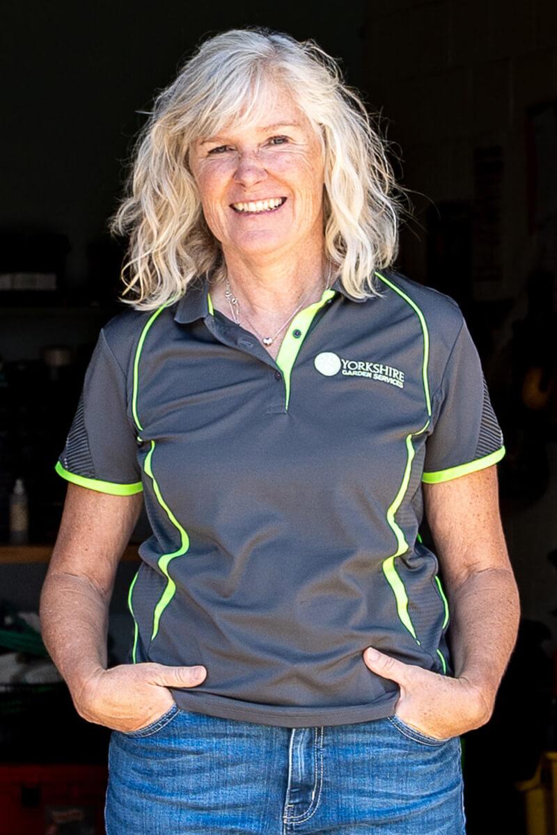 woman standing with hands in pockets smiling
