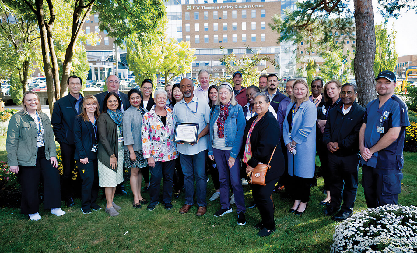 Large group of people outside in a garden posing for a picture