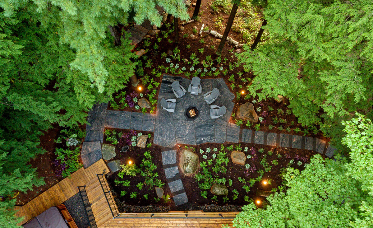 aerial image of a natural landscape with a semi-circle of chairs on a stone patio surrounded by plants