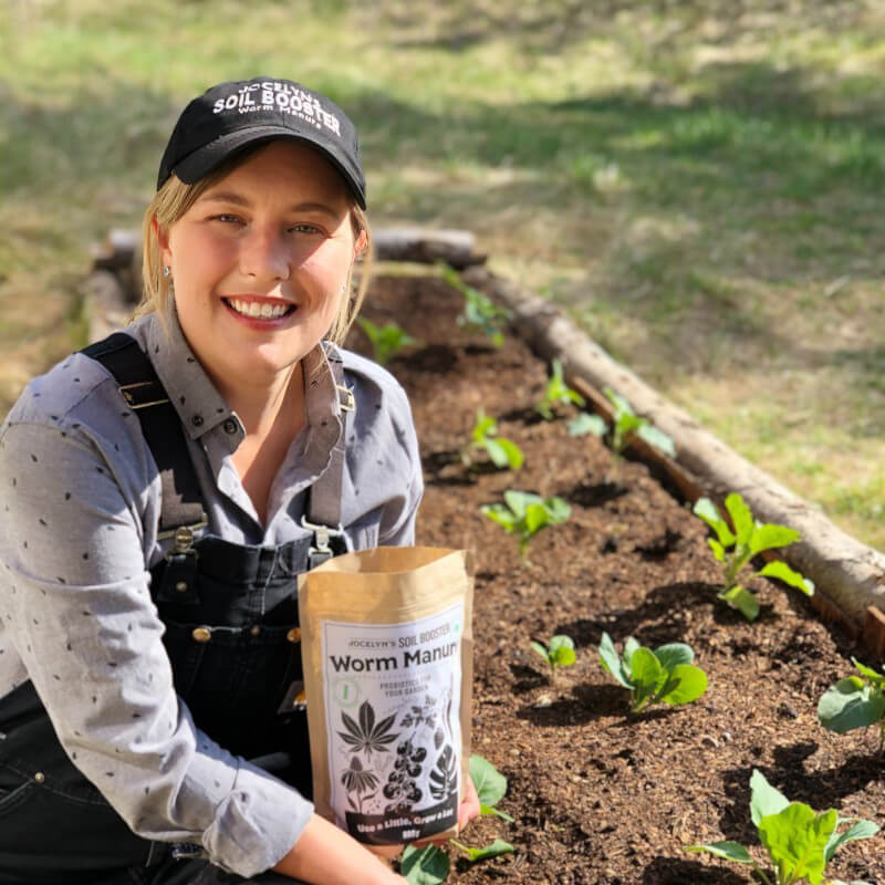 woman in a garden holding a bag of compost