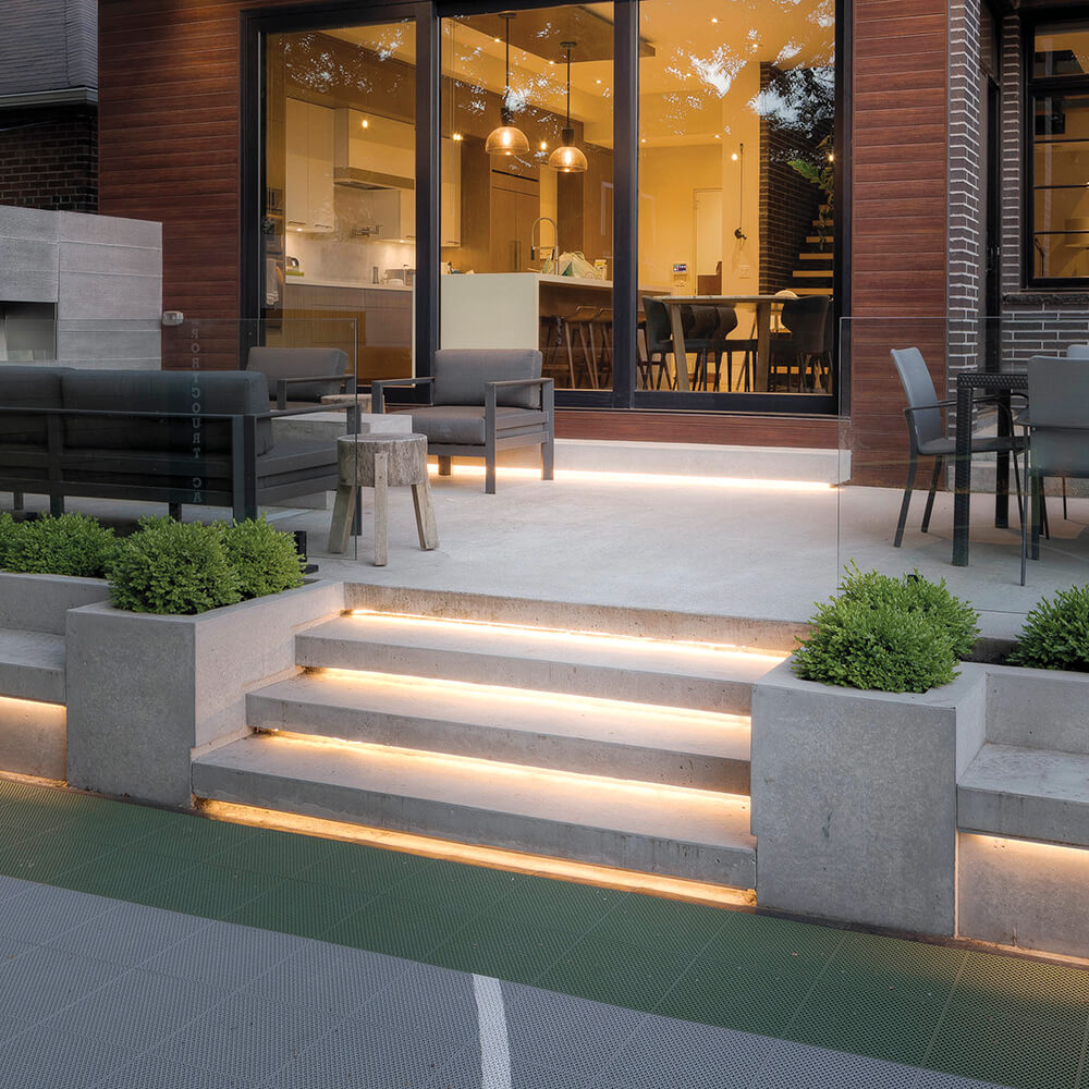 concrete steps with under lighting leading to a house