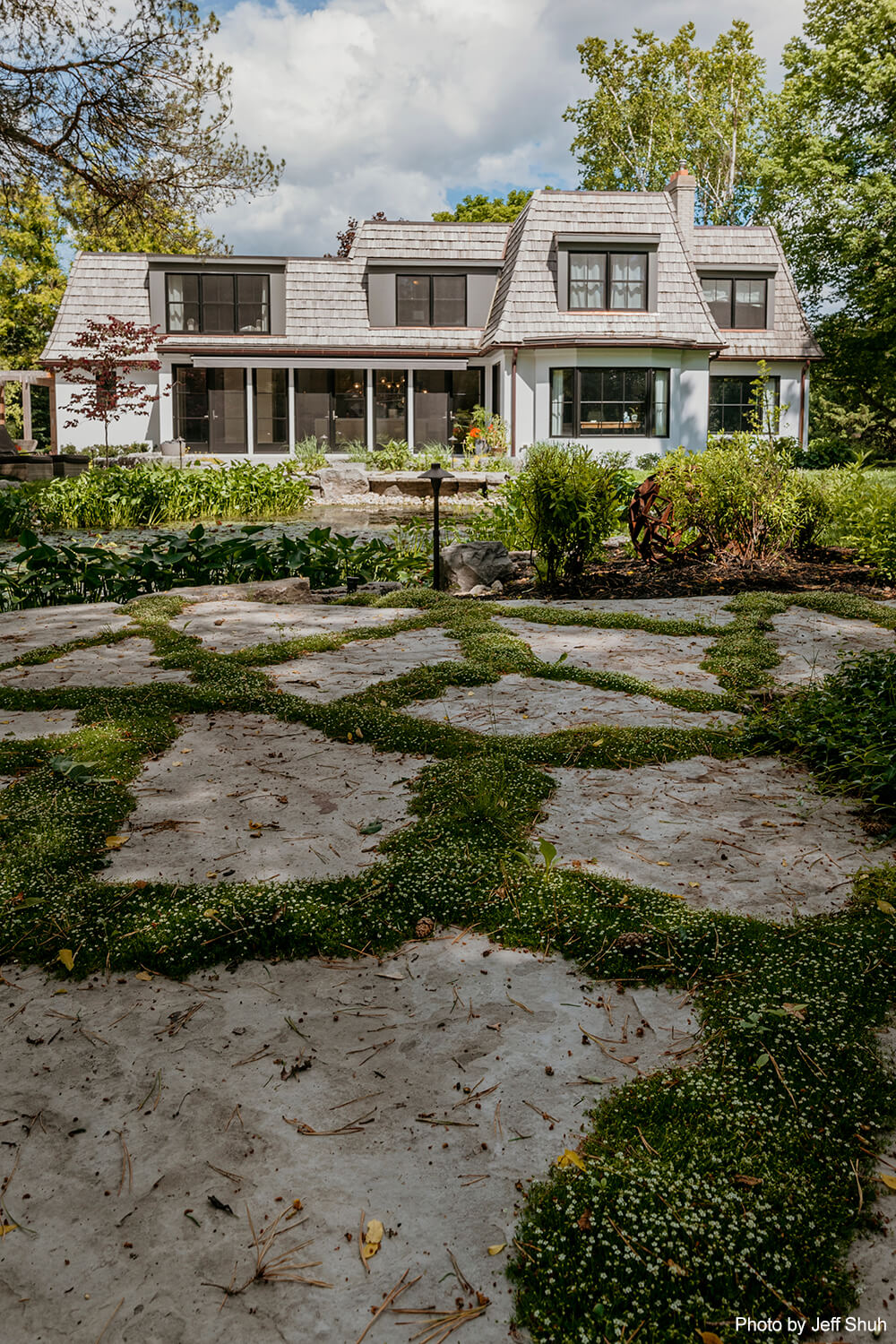 natural stones and grass leading up to a house in the distance