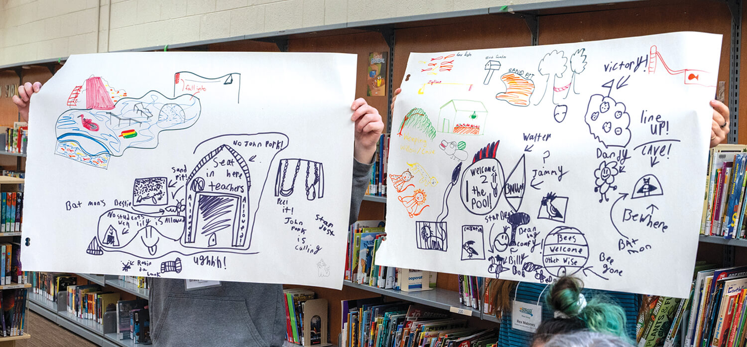 two large drawing being held up for people to see