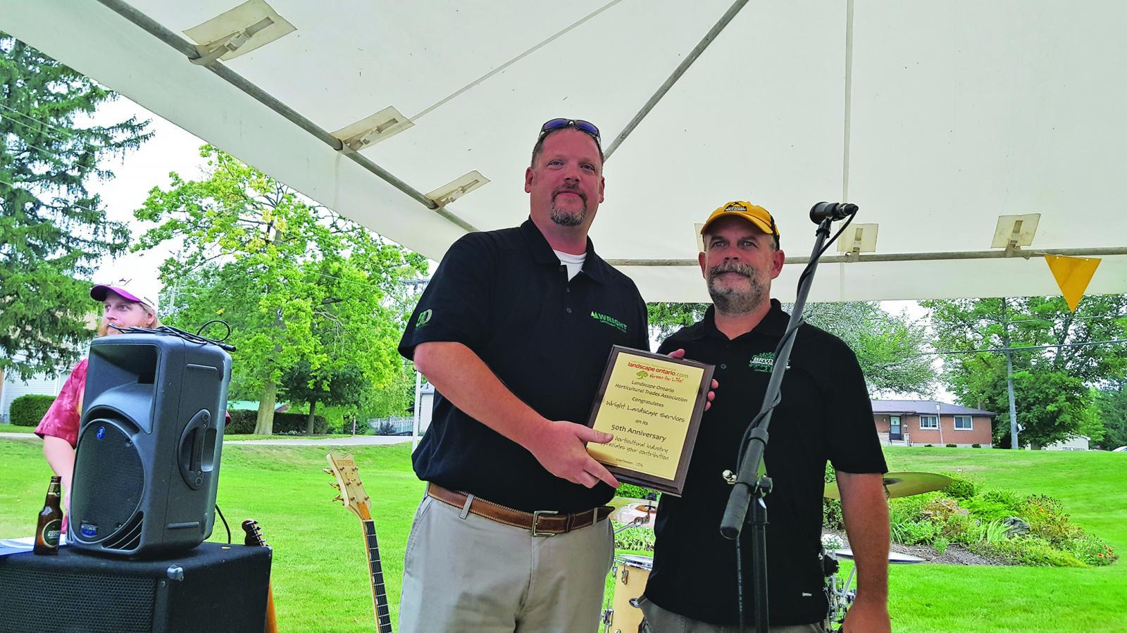 Dave Wright (left) accepts a plaque from LO President Paul Brydges.