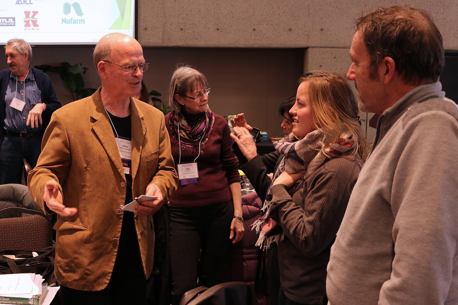 Keynote speaker, Mark Krautmann (left), talks with attendees during a break.