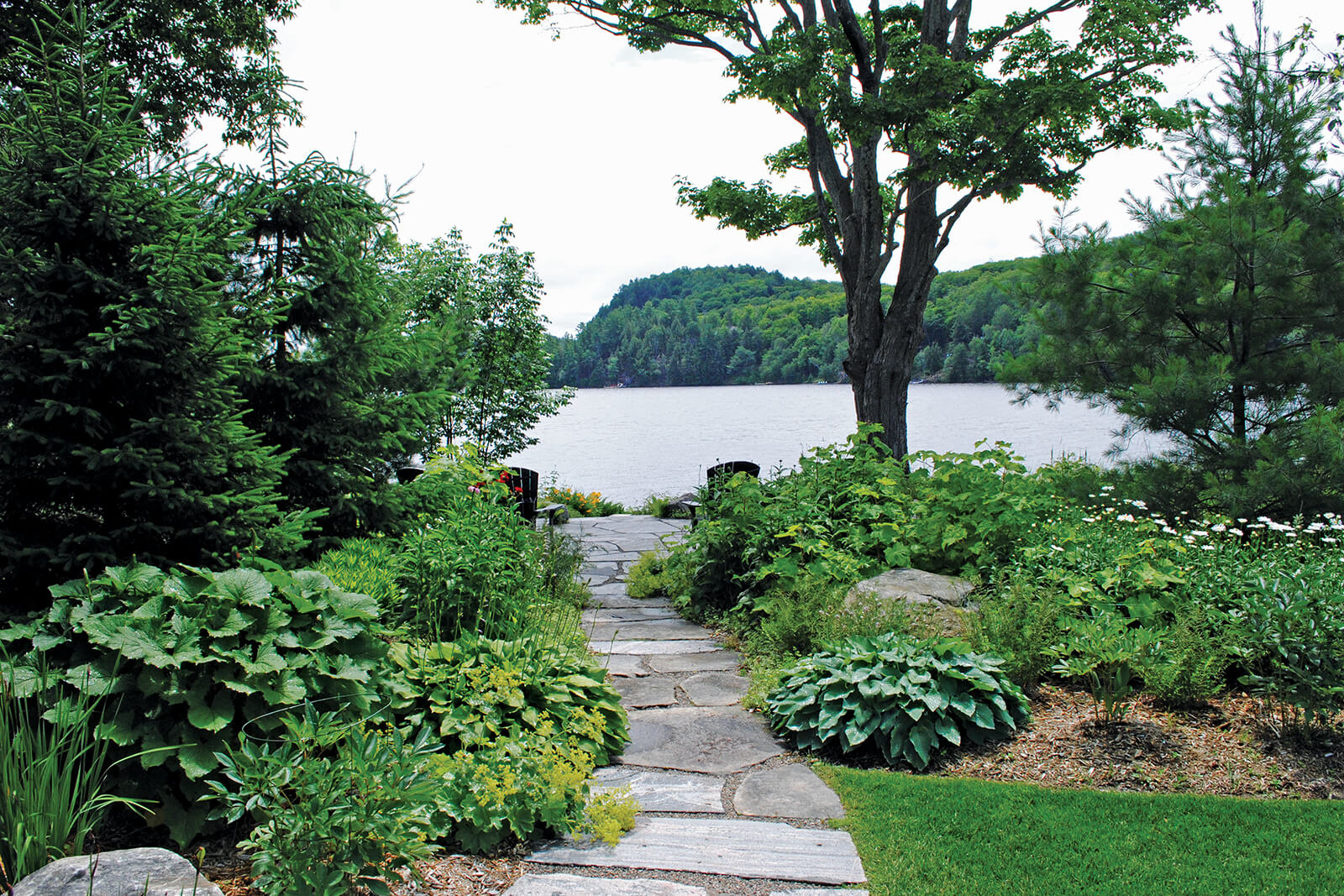 The spectacular view of Fairy Lake is the clear focal point of the property, but it also created some design challenges. It was important to the homeowners to naturalize the shoreline, mitigate erosion from water runoff, and retain the large existing sugar maple.