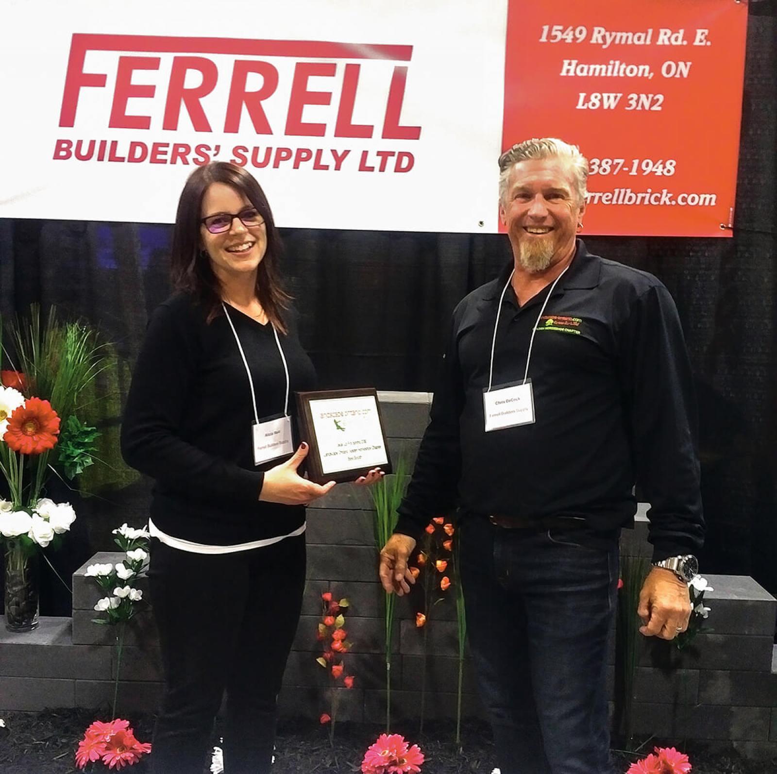 Alicia Reid and Chris DeCock from Ferrell Builders’ Supply accept the best booth award.