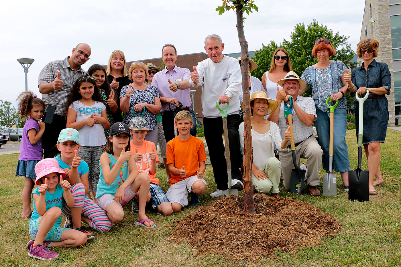 Milton Mayor Gord Krantz (centre with shovel) is surrounded by gardening enthusiasts during a Garden Days tree planting celebration at Milton Public Library.