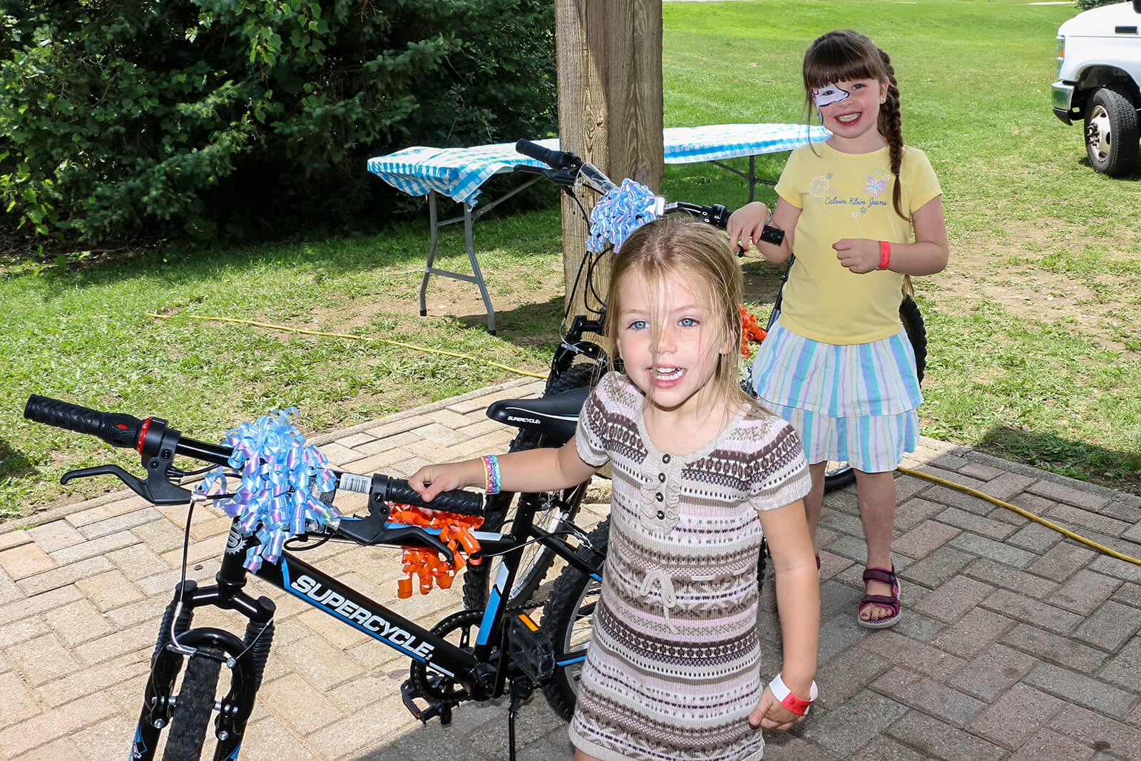 Eden Moriarty, 6 (back) and Brooke Garner, 4, held the winning raffle tickets and each took home a brand new bicycle courtesy of the Waterloo Chapter.