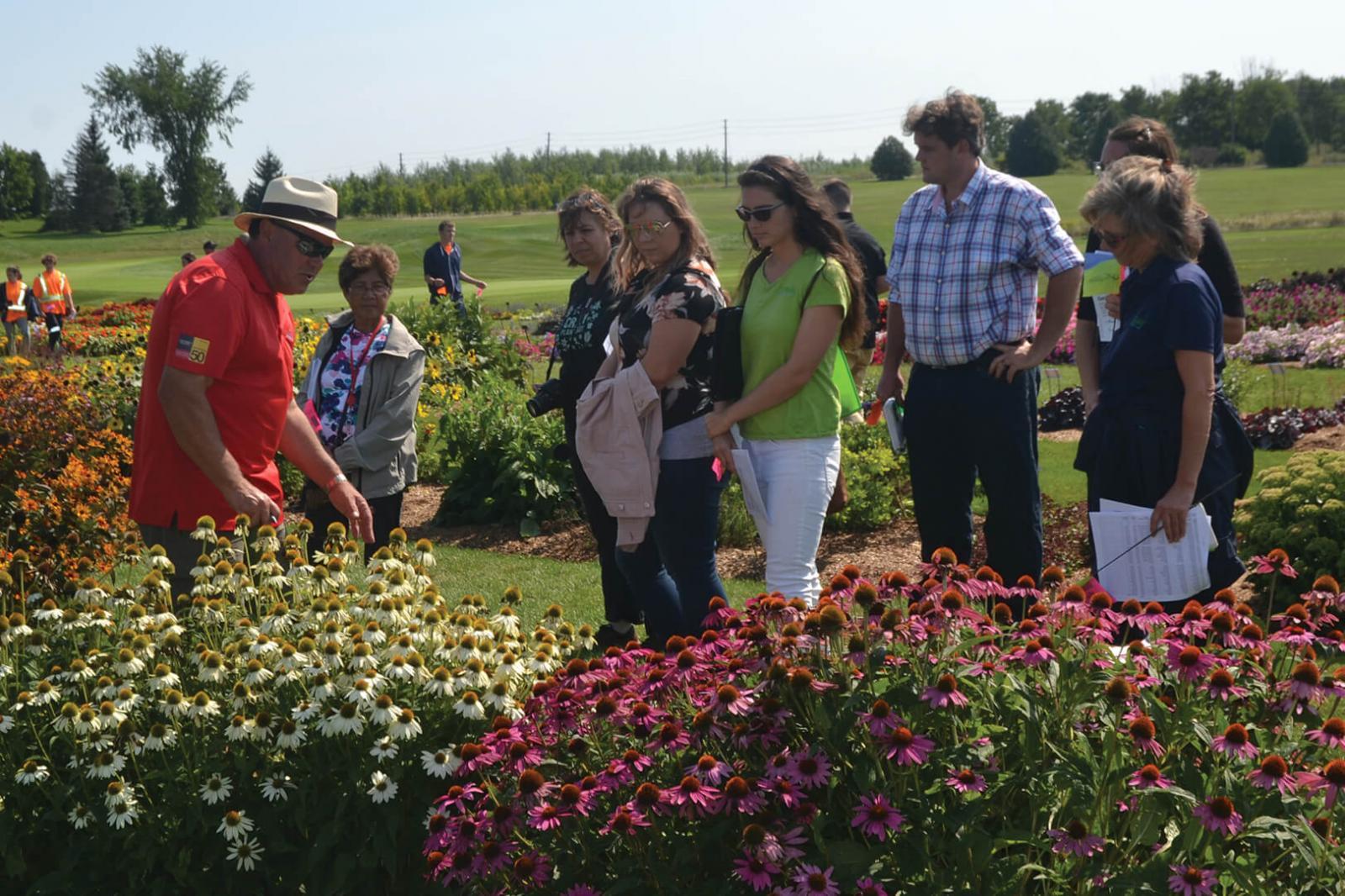 Rodger Tschanz (left), leads a tour of the trial garden site in Guelph.
