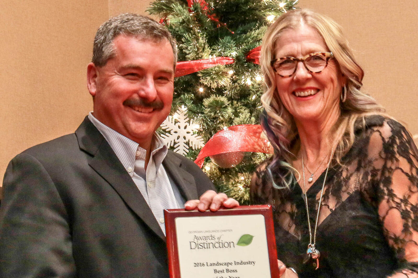 Nick Solty accepts an award from Teresa Matamoros.