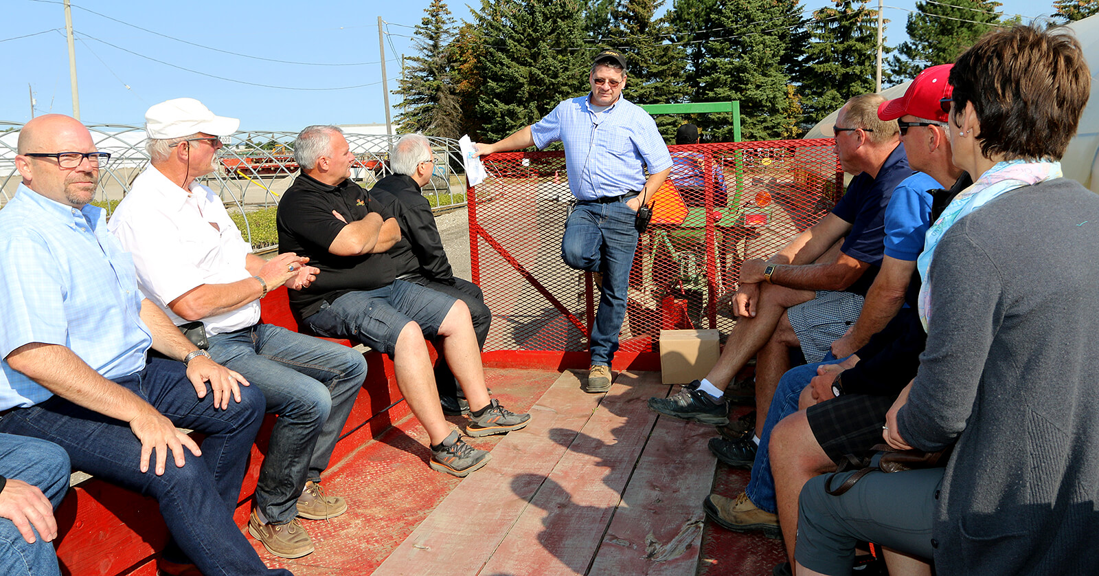 Auction attendees ride along with BTN’s Jeff Olsen (left) and Tim Twohey (centre) for a morning tour of the company’s 135 acre property.