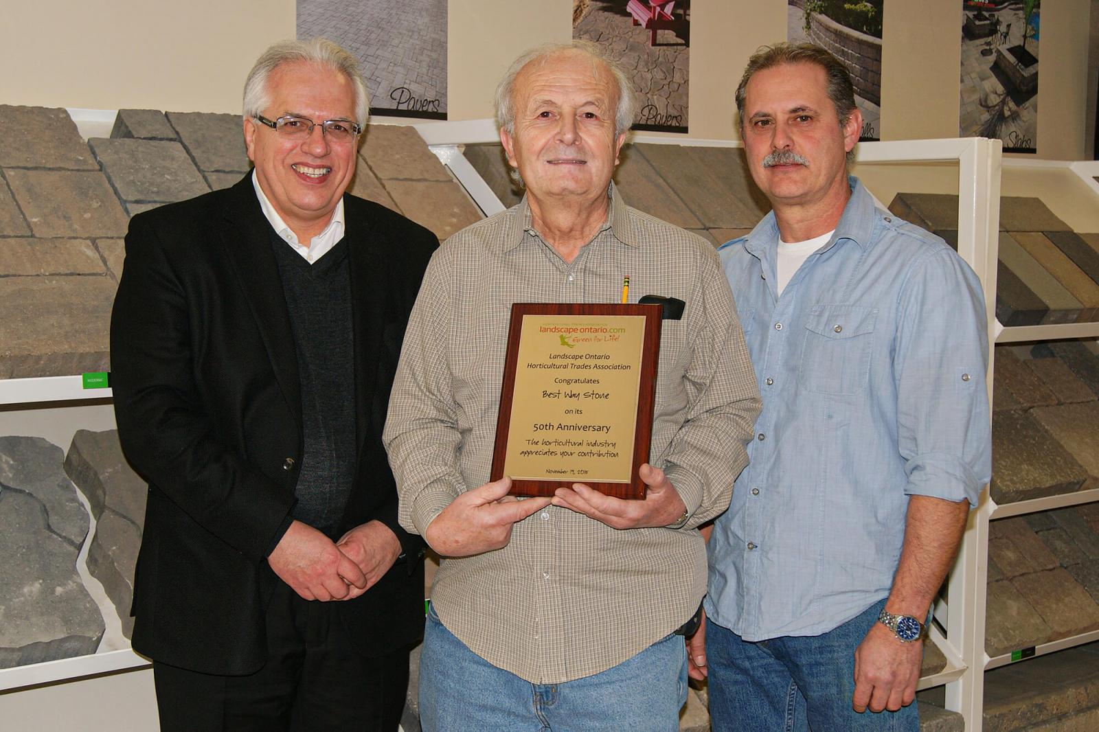 Landscape Ontario executive director Tony DiGiovanni (left) presented Frank Pacitto and Remo (Ray) Pignatelli of Best Way Stone with a commemorative plaque in honour of the company’s 50th anniversary.