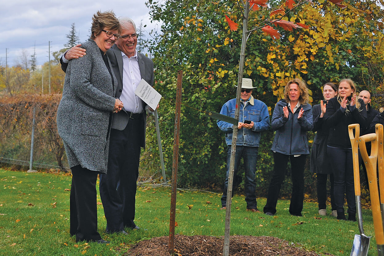 Kathleen Pugliese receives a hug, a plaque and a tree for her years of service to the association.