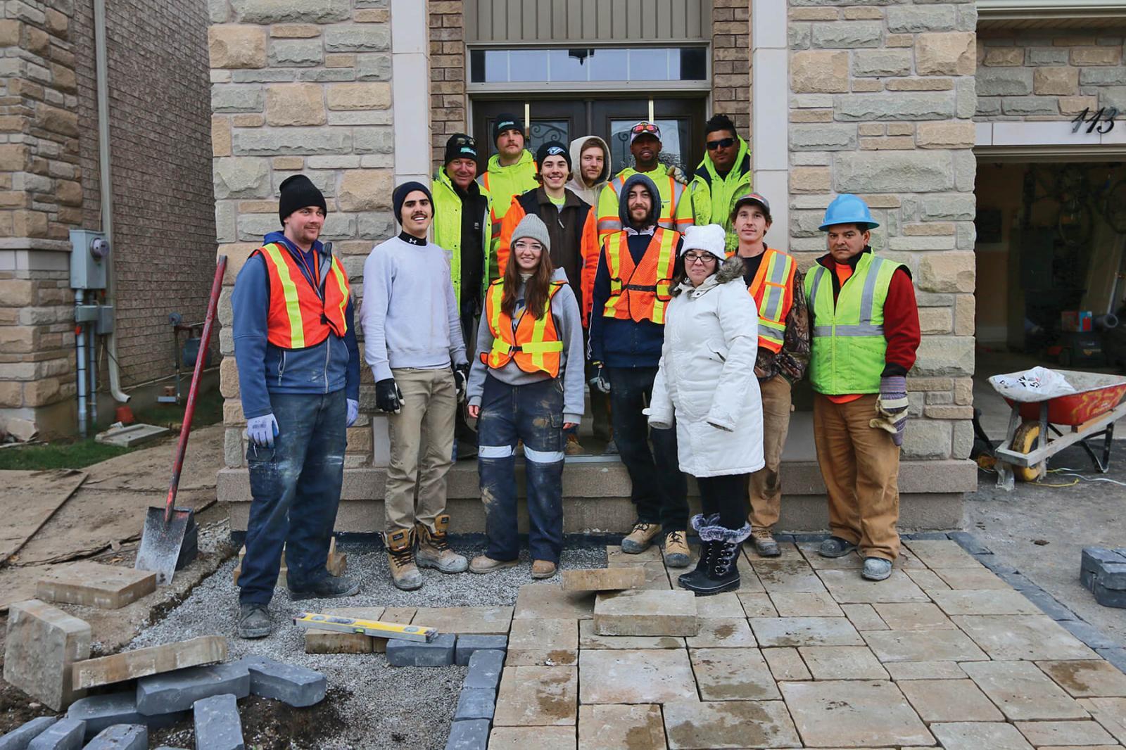 Chris Ray of Humber Valley Landscaping (first in back row), and his team of industry members and students from the Humber College Landscape Technician program and homeowner Cory Allard (in white).