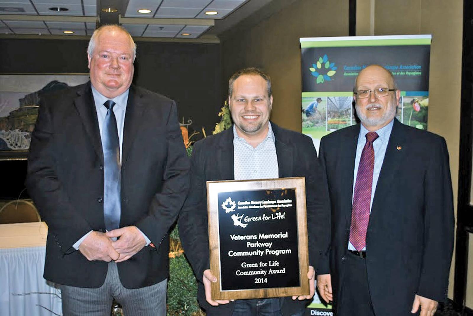 Bill Hardy, chair of the CNLA Public Relations Committee, presents Grant Harrison, London Chapter president, and Barry Sandler, executive director of the Veterans Memorial Parkway Community Program, with the Green for Life Community Award.