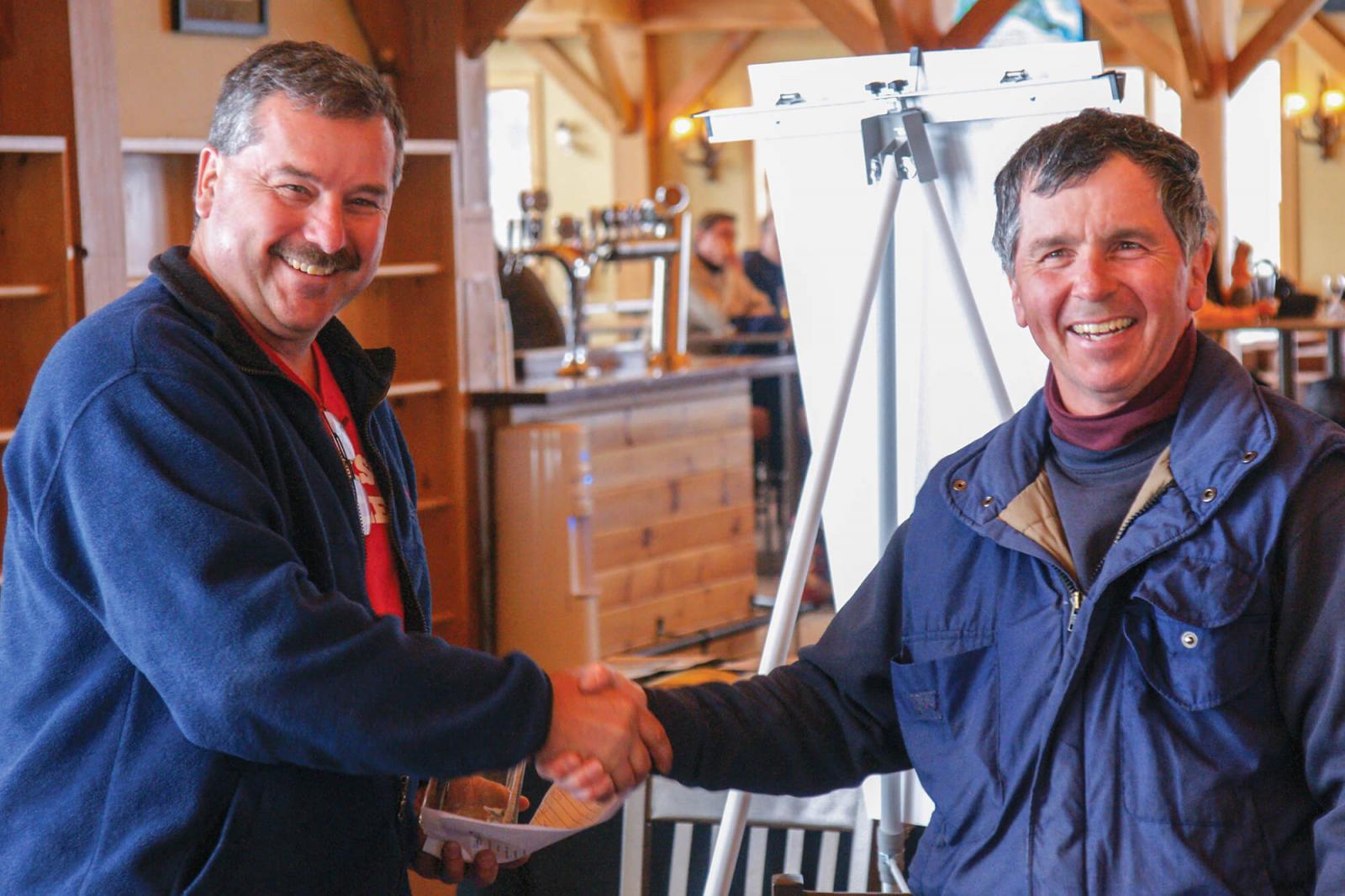 Nick Solty, left, presents Frank Solty with the trophy for fastest run of the day on the ski slopes.
