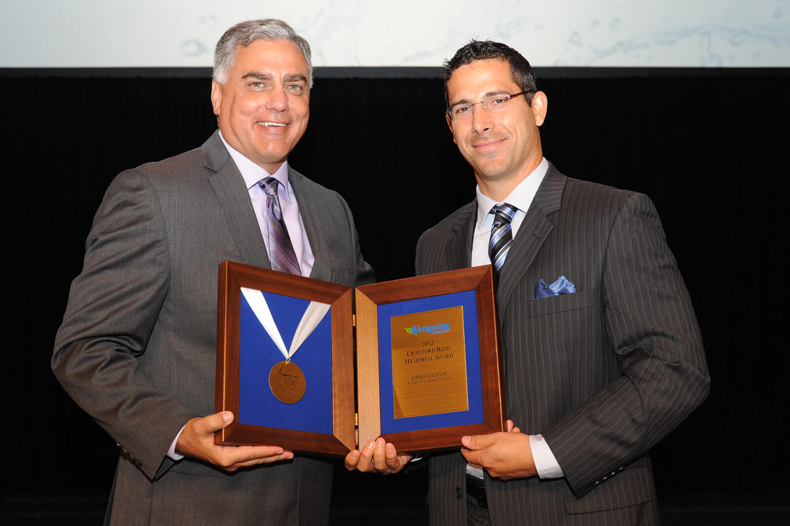 Toro president Phil Burkart, left, presents Chris Le Conte of Smart Watering Systems with the 2012 Crawford Reid Memorial Award.