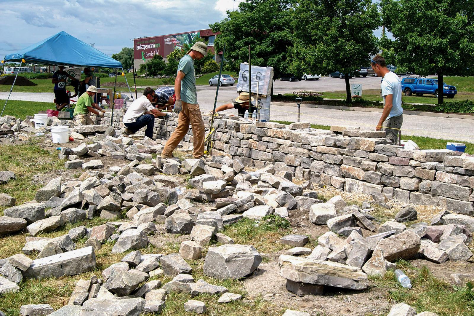 The first dry stone course at Landscape Ontario home office in Milton drew ten people. In photo students test themselves on the wall, which they had built the previous day in the instructional part of the course, only to tear it down the next day and build it again to be tested on what they had learned.