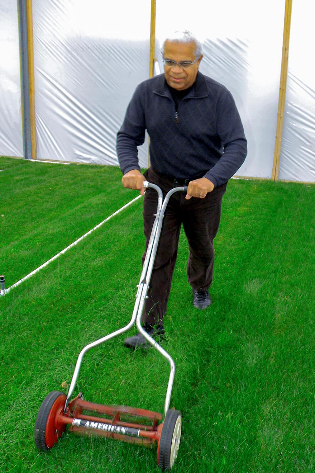 In the LO greenhouses in Milton, volunteer Don Voorhees cuts grass that will be used in LO’s Canada Blooms garden.