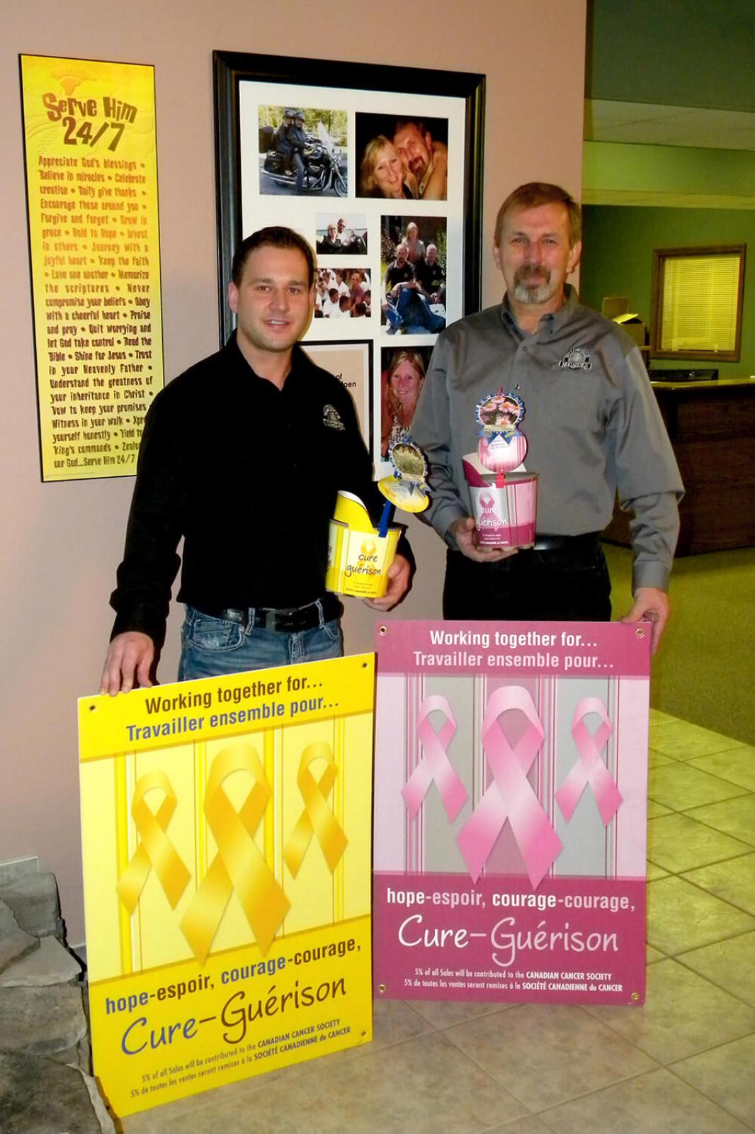 Michael Della Valle, left, and John Langendoen show the special pink and yellow pots, along with the posters available to garden centres.