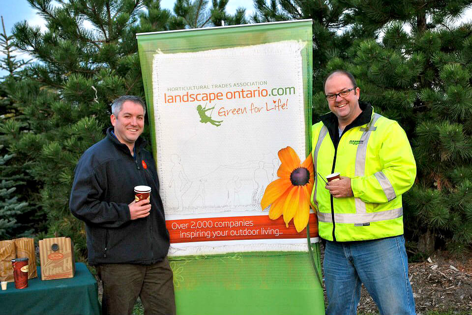 Chris Burns, president of the Ottawa Chapter and Clintar Landscape Management-Ottawa, on left, and Ed Hansen, vice president of the Ottawa Chapter and Hansen Lawn and Garden, take a break after volunteering at the Ottawa Cancer Survivors Park.