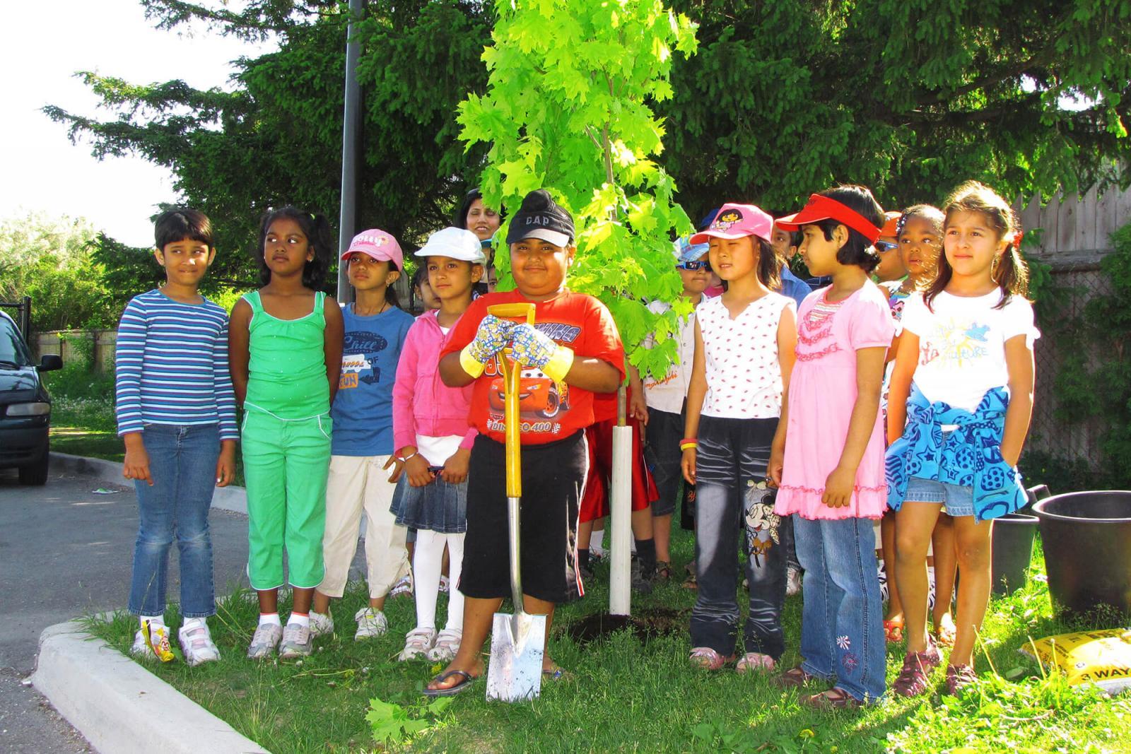 The children from Lancaster Elementary School in Mississauga stand proudly by their new maple tree donated by Landscape Ontario.