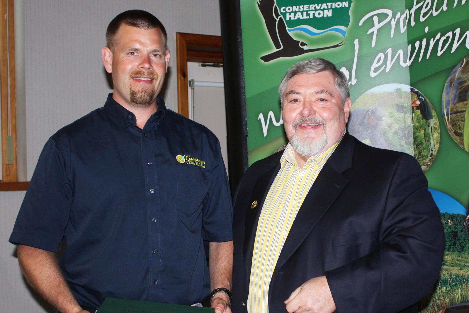 Nathan Helder, left, receives his award from Conservation Halton chair Brian Penman.