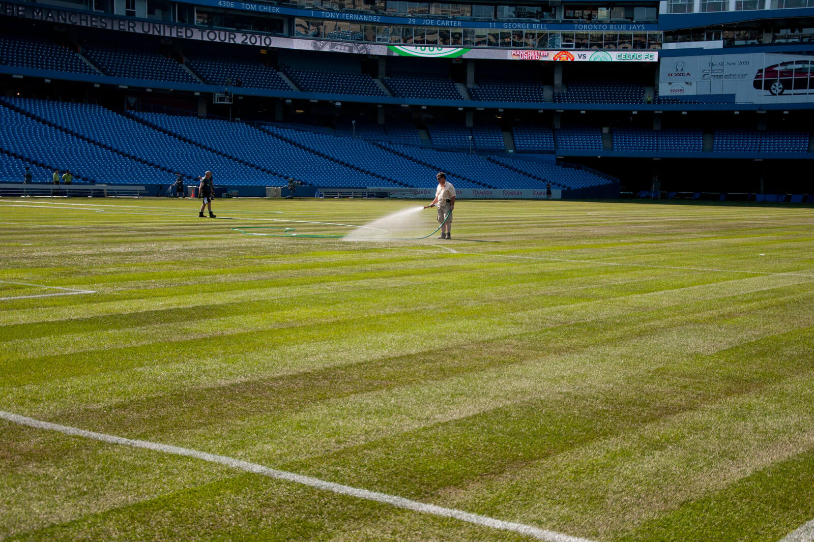 President of Greenhorizons, Ron Schiedel, puts water to the newly laid sod at the Rogers Centre, just before game time.