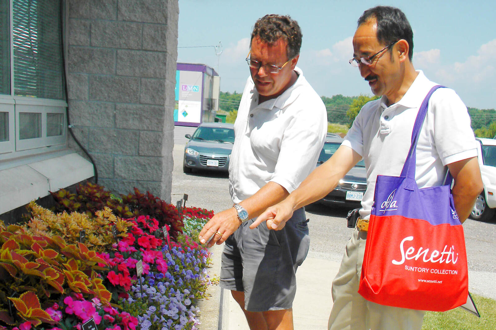 Suntory’s executive general manager Yasuyuki Murakami Ph.D., of Japan, was pleased with what he saw at the LO trial gardens. In photo, garden manager Rodger Tschanz shows Suntory’s executive some of his plants that are part of the trials.