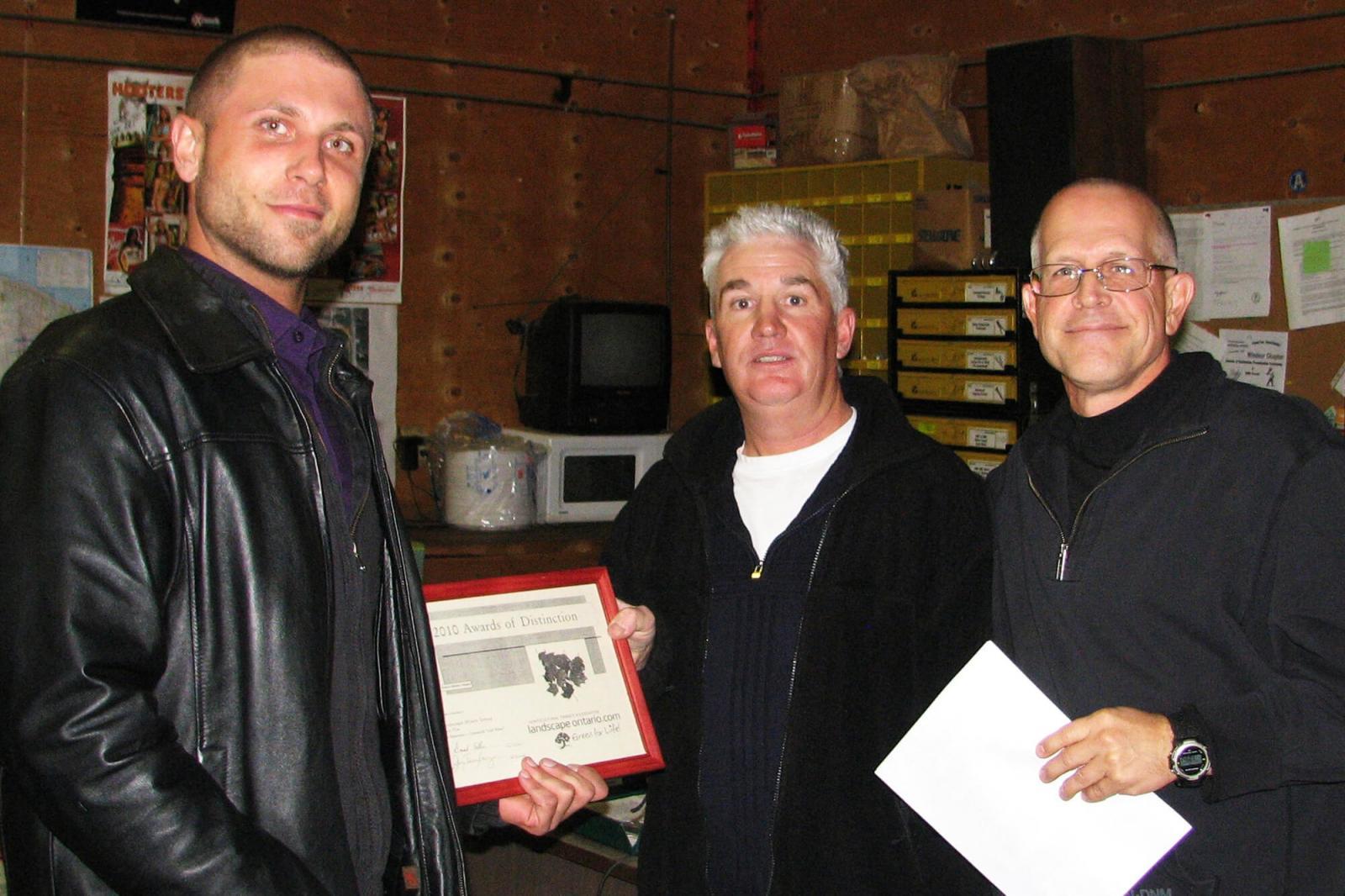 Chris Kaiser of the The Landscape Effects Group receives an award from Mark Williams and Jay Terryberry.