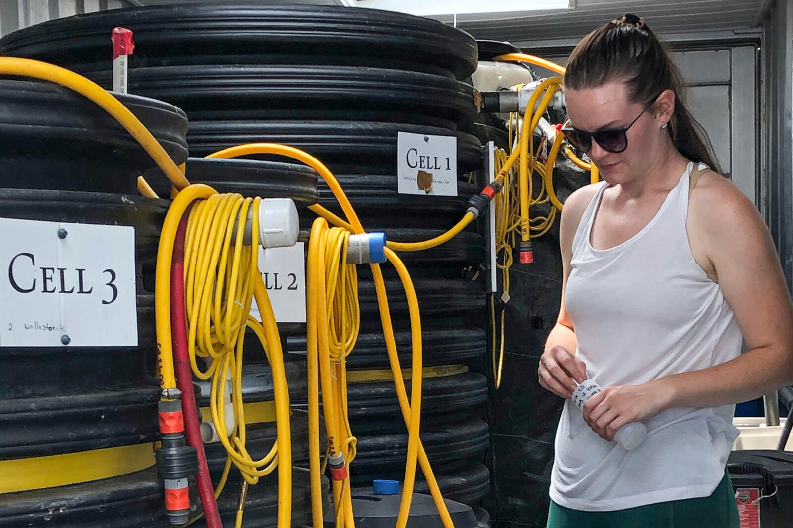 Technician Elizabeth Huber-Kidby prepares to take water samples from each of the eight cells, each one containing a different filter media as part of a research project led by Dr. Ann Huber of the Soil Resource Group.